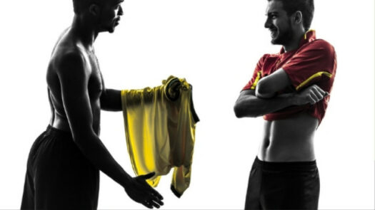 Zwei Fußballspieler tauschen ihre Trikots